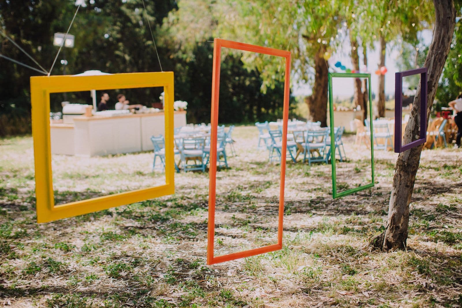 Brightly painted empty picture frames hung among the trees
